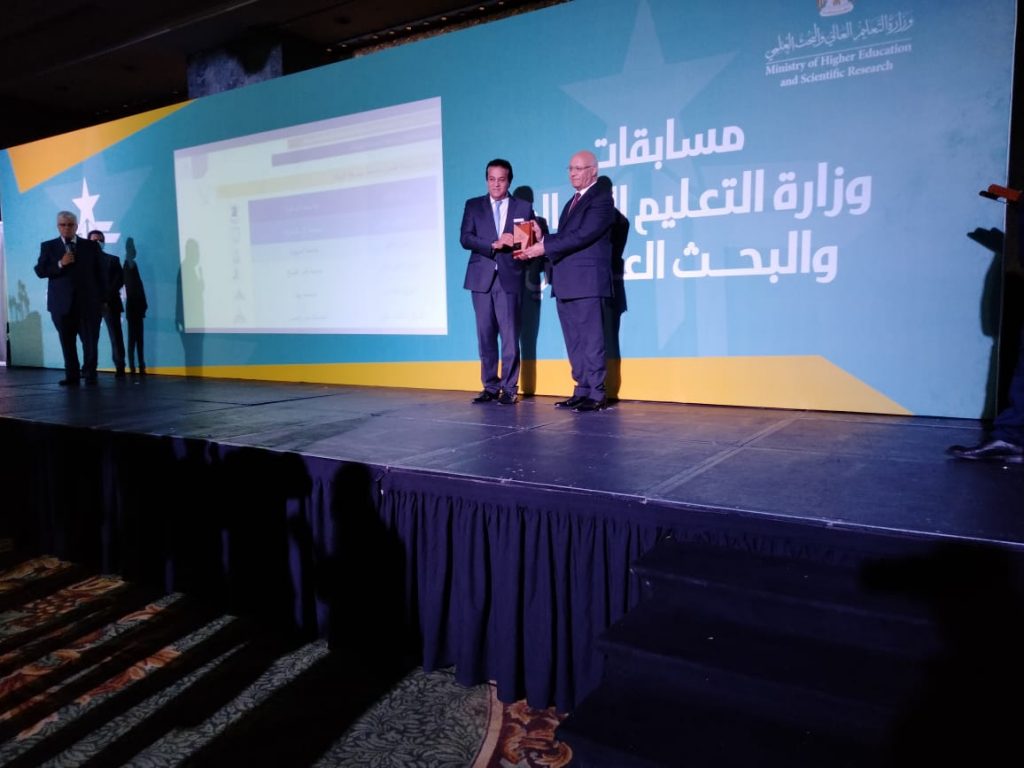 حصدت جامعة بنها 3 مراكز ضمن مسابقات الجامعات المصرية للعام الجامعي 2020/2021، والتي أعلن نتائجها الدكتور خالد عبدالغفار وزير التعليم العالي والبحث العلمي. وشارك في حفل تسليم الجوائز الدكتور جمال سوسة المشرف على قطاع خدمة المجتمع وتنمية البيئة ، حيث فازت الجامعة بالمركز الثاني " أعمال النحت " في مسابقة طلاب الجامعات وأعضاء هيئة التدريس حول الصورة البصرية للعاصمة الإدارية الجديدة ، والتي جاءت بناء على توجيهات رئيس الجمهورية بشأن ضرورة عمل هوية بصرية للعاصمة الإدارية الجديدة. كما فازت الجامعة بالمركز الثالث في مسابقة أفضل جامعة صديقة للبيئة ، وكذلك المركز الثالث في مسابقة مشروعات تنسيق الموقع. من جانبه وجه الدكتور ناصر الجيزاوي القائم بأعمال رئيس الجامعة التهنئة لكل فرق العمل المشاركة في المسابقات الثلاثة على مستوى قطاعات الجامعة ، وكذلك الشكر لقطاع خدمة المجتمع لدوره فى تفعيل دور جامعة بنها كجامعة صديقة للبيئة وإعداد ملف المشاركة في المسابقة. كما وجه " الجيزاوى " الشكر للدكتور شمس القرنفلي عميد كلية الفنون التطبيقية وفريق العمل والطلاب المشاركين فى المسابقة من خلال اعمالهم الابداعية وتميزهم فى أعمال النحت والحصول على المركز الثانى فى مسابقة الصورة البصرية للعاصمة الإدارية الجديدة. الجدير بالذكر أن الدكتور خالد عبدالغفار وزير التعليم العالي والبحث العلمي، قد أعلن اليوم الاثنين، نتائج مسابقات الجامعات التي أطلقتها الوزارة بين الجامعات المصرية، والتي شملت عدة مجالات، وهي: الاستعداد للعام الدراسي 2020/2021، وجهود مواجهة جائحة فيروس كورونا المستجد، وأفضل موقع إلكتروني على مستوى الجامعات والمراكز والمعاهد البحثية، وأفضل مشروع تطبيقي مُرتبط بالمجتمع، وأفضل جامعة حكومية في مجال الدراسات العليا والبحوث والأبحاث التطبيقية المنشورة من حيث الإبداع وارتباطها بالصناعة، وأفضل جامعة صديقة للبيئة، بالإضافة إلى المنافسة بين طلاب الجامعات وأعضاء هيئة التدريس لتجميل الصورة البصرية للعاصمة الإدارية الجديدة، وذلك بحضور اللواء أحمد زكي عابدين رئيس مجلس إدارة شركة العاصمة الإدارية الجديدة، ود. أيمن عاشور نائب الوزير لشئون الجامعات، ولفيف من رؤساء ونواب الجامعات الحكومية والخاصة، والمراكز والمعاهد والهيئات البحثية.  وأكد الوزير في كلمته، أن الهدف من هذه المسابقات هو تحفيز الجامعات المصرية، والحرص على زيادة التواصل بينها في الأقاليم المختلفة عن طريق المنافسة فيما بينها في عدة مجالات تعتمد في المقام الأول على أهداف التنمية المستدامة، والتي شملت: التعليم والطلاب والبحث العلمي وخدمة المجتمع والربط بين العلم بالصناعة والمجتمع المحلي، مشيرًا إلى أهمية التوسع في المسابقات خلال السنوات القادمة لتشمل عدد أكبر من مشاركات الجامعات الدولية، ليصبح المنافسة بين جامعاتنا المصرية والجامعات الأخرى خارج حدود الدولة المصرية.