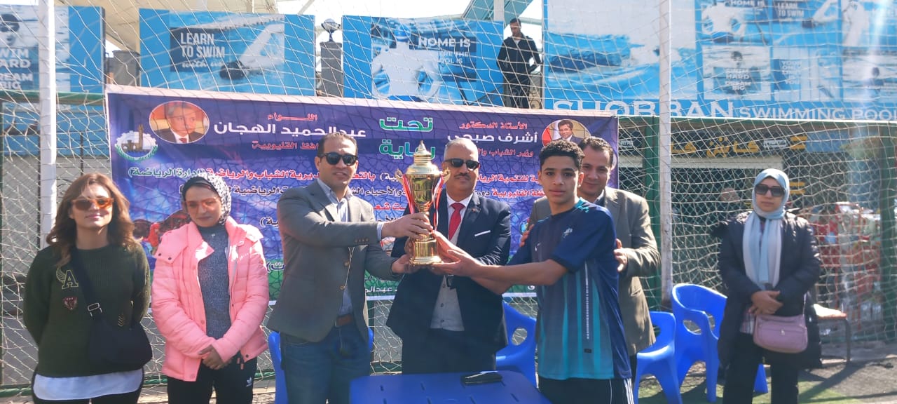 شهد الدكتور محمود الصبروط وكيل وزارة الشباب والرياضة بالقليوبية ، نهائى دورى الاندية الصغيرة والاحياء الشعبية ، الذى نظمته مديرية الشباب والرياضة بالقليوبية  ، بالتعاون مع الإدارة المركزية للتنمية الرياضية - الإدارة العامة للقاعدة الشعبية، على ملاعب جمعية الشبان العالمية ببنها ،   تحت رعاية الدكتور أشرف صبحي وزير الشباب والرياضة . شهدت النهائيات لدوري الأندية الصغيرة والاحياء الشعبية منافسات قوية بين الفرق المتنافسة سعيًا لخطف بطاقة الصعود للتصفيات النهائية بين فريقى عرب العيايدة ودمنهور شبرا فى خماسى كرة القدم والتى انتهت بفوز فريق عرب العيايدة ٣/صفر  ، بحضور الدكتور محمد عبدالمؤمن وكيل المديرية لشئون الرياضة ، نيفين ممدوح ، ميرام السيد مسؤول الاداره المركزيه للتنميه الرياضيه -  الاداره العامه للقاعده الشعبيه ، والكابتن محمد عزازى مدير ادارة الرياضة بالمديرية. اعرب وكيل وزارة الشباب والرياضة بالقليوبية ، عن سعادته لفوز الفرق الفائزة ، مهنئا فريق عرب العيايدة بطل دورى الاندية الصغيرة والاحياء الشعبية فى خماسى كرة القدم، موضحا ان دورى الاندية الصغيرة تضمن ايضا « كرة اليد ، وتنس الطاولة » وان الدورى الاندية الصغيرة جاء على مدار خمسه اشهر وحصلت الفرق الفائزة فى كرة اليد و تنس الطاولة على جوائز مالية ، مؤكدا على إستراتيجية وزارة الشباب والرياضة، بتشجيع وتوسيع قاعدة ممارسة الرياضة والمنافسة بين أطفال وشباب الأندية الصغيرة والأحياء الشعبية داخل المحافظة  يأتي فعاليات دورى الاندية الصغيرة والاحياء الشعبية ضمن سياسة وزارة الشباب والرياضة لنشر الرياضة داخل المجتمع وجعلها أسلوب حياة ، وذلك فى ضوء توجيهات السيد الرئيس عبدالفتاح السيسي رئيس الجمهورية بتشجيع المواطنين على ممارسة الرياضة ، برعاية الدكتور اشرف صبحى وزير الشباب والرياضة ، و بتوجيهات الدكتور محمود الصبروط وكيل وزارة الشباب والرياضة بالقليوبية ، واشراف الدكتور محمد عبدالمؤمن وكيل المديرية لشئون الرياضة ، والكابتن محمد عزازى مدير ادارة الرياضة بالمديرية.